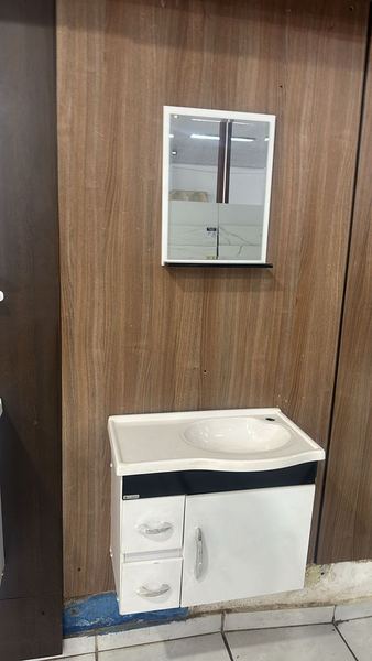 Gabinete branco com faixa preta, duas gavetas e uma porta, com espelheira