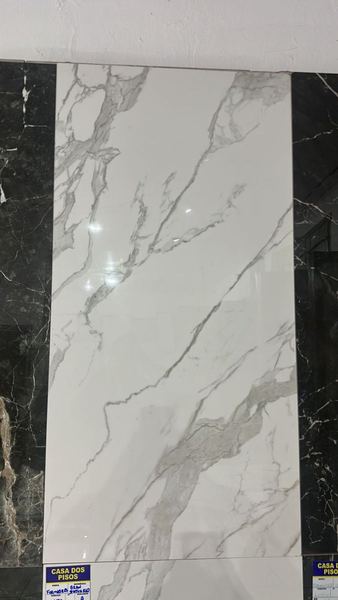 Porcelanato branco tipo calacatta entre amostras escuras